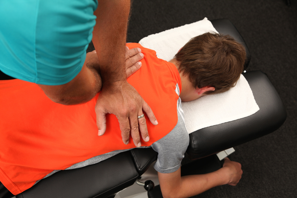 Chiropractor treating a teenager